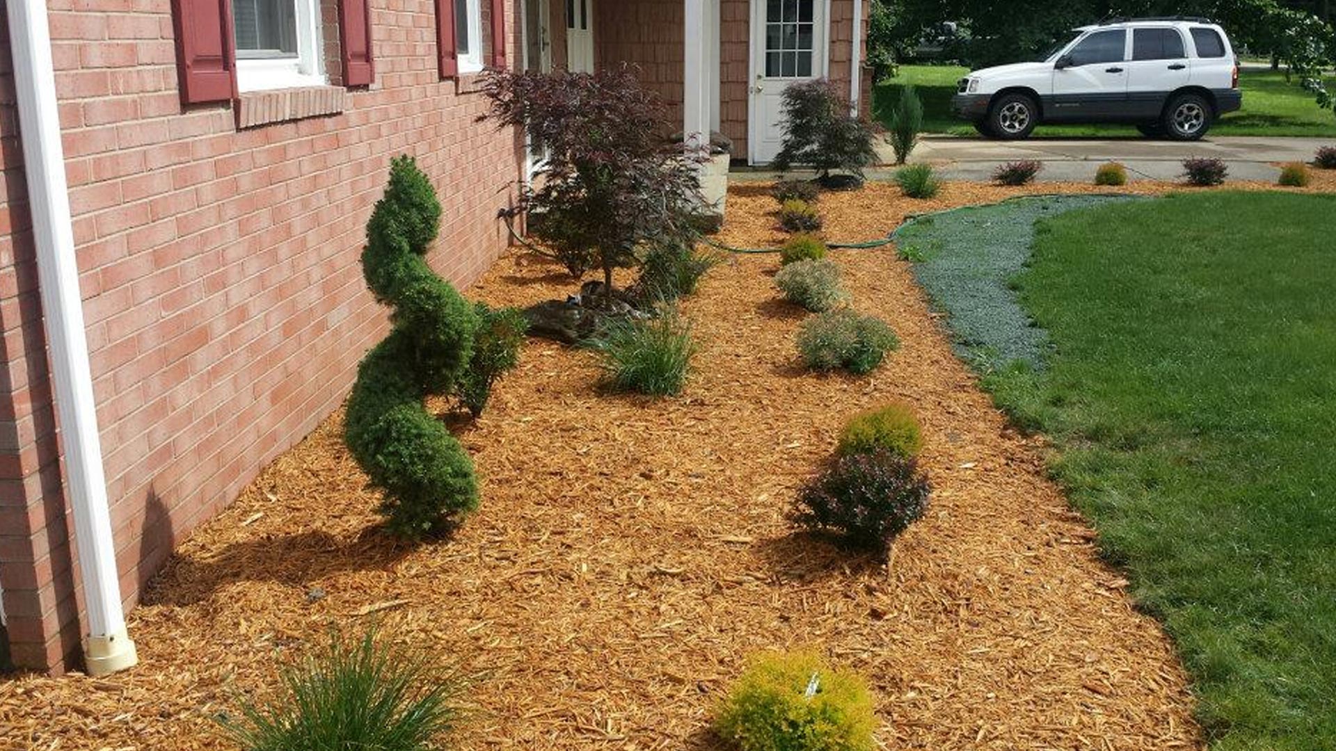 Landscaping installed featuring new plants, shrubs, and mulch at a property in Geneva, OH.