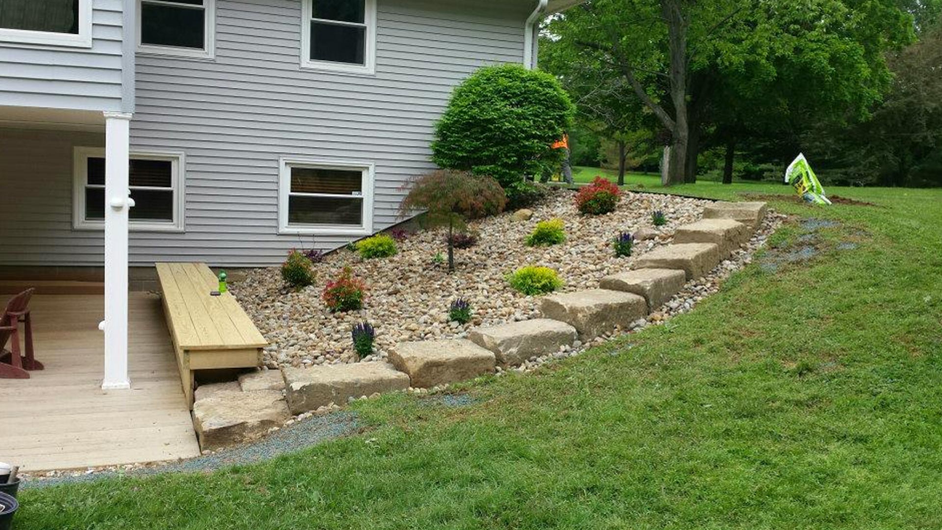 Landscaping with large boulders and river rock installed in Geneva, OH.