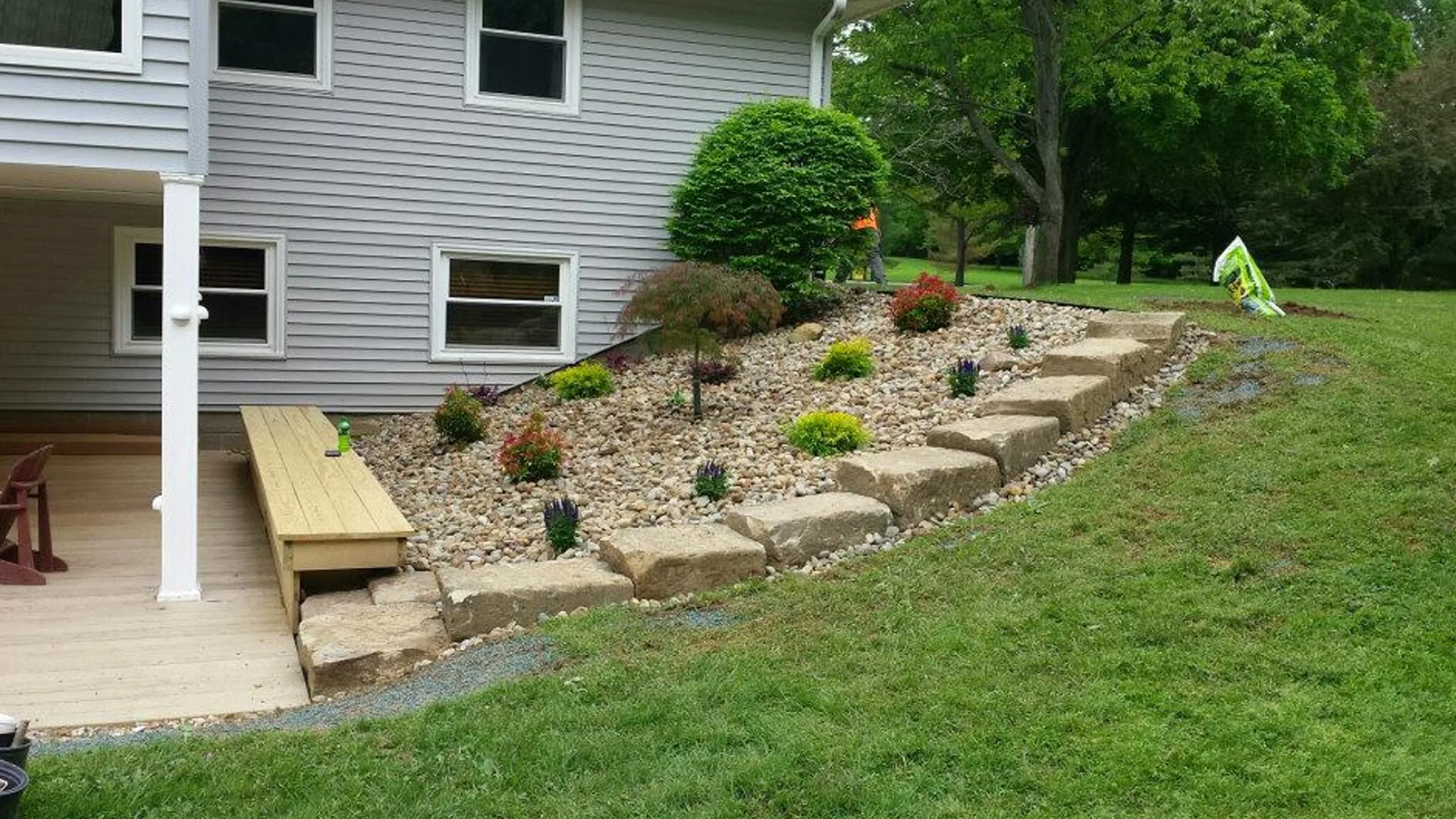 Landscaping with large boulders and river rock installed in Geneva, OH.